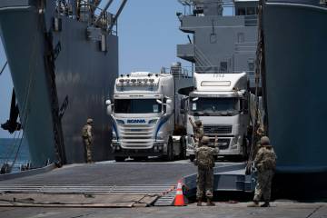 U.S. Army soldiers gestures as trucks loaded with humanitarian aid arrive at the U.S.-built flo ...