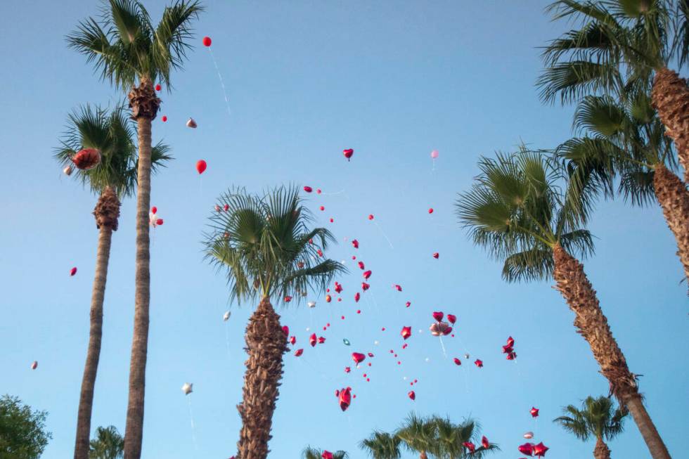 Red balloons are released into the sky during a candlelight service for Kayla Harris at Craig R ...