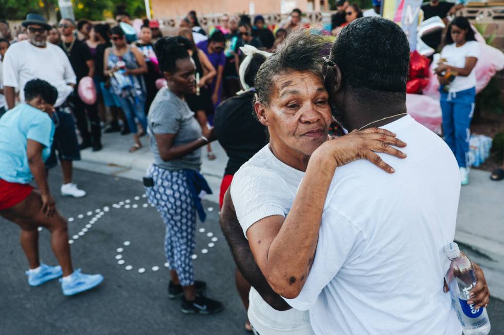 Mourners hug during a vigil for Kayla Harris, who was killed in a quintuple homicide on June 25 ...