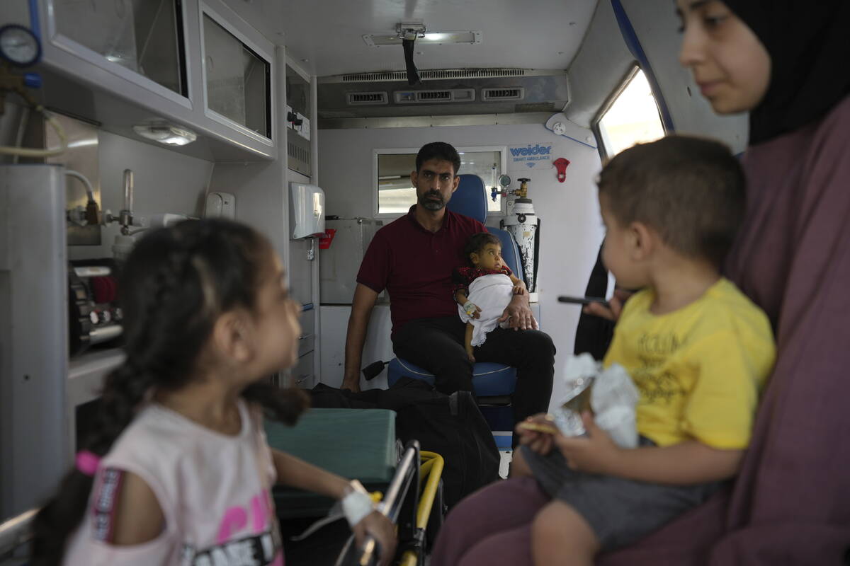 Palestinian children with chronic diseases sit with their relatives before they leave the Gaza ...