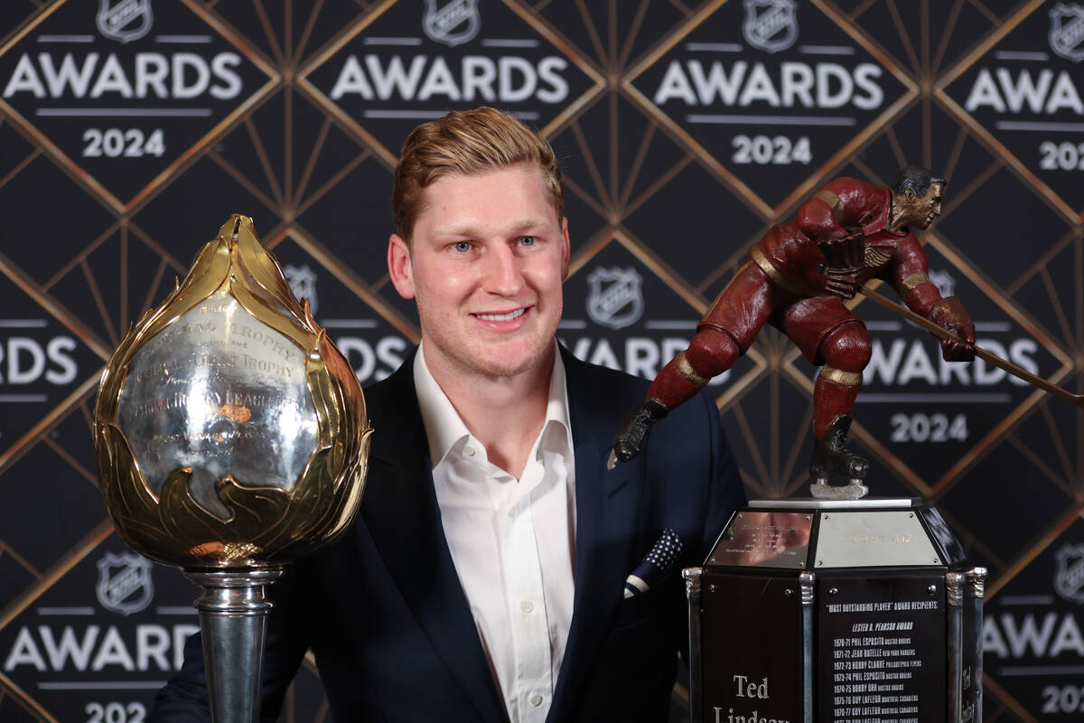Colorado Avalanche center Nathan MacKinnon poses with the Hart Memorial Trophy and the Ted Lind ...