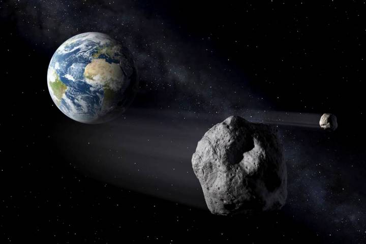 In this artistic rendering, two asteroids fly past Earth. An asteroid will whiz harmlessly past ...