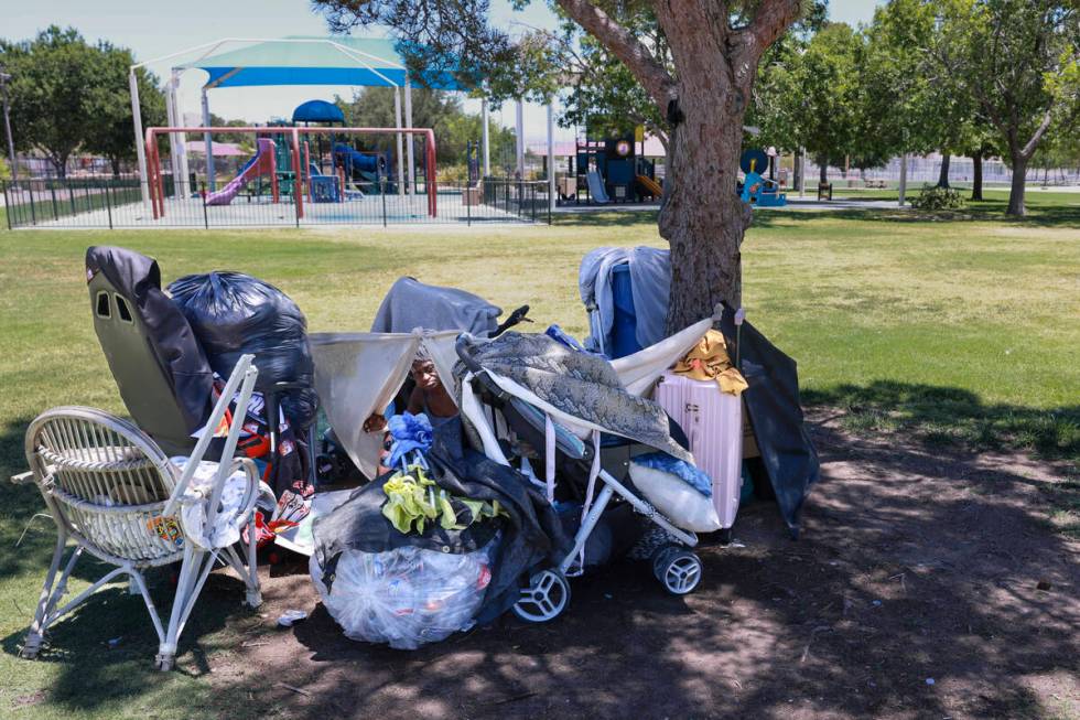 Nathalie Brown, 57, takes shelter from the sun with her belongings at Justice Myron E. Leavitt ...