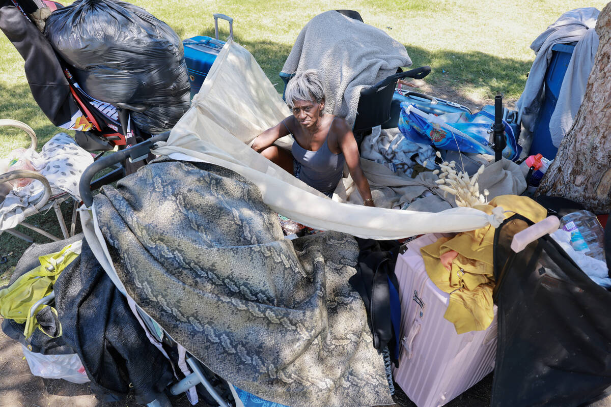 Nathalie Brown, 57, takes shelter from the sun with her belongings at Justice Myron E. Leavitt ...