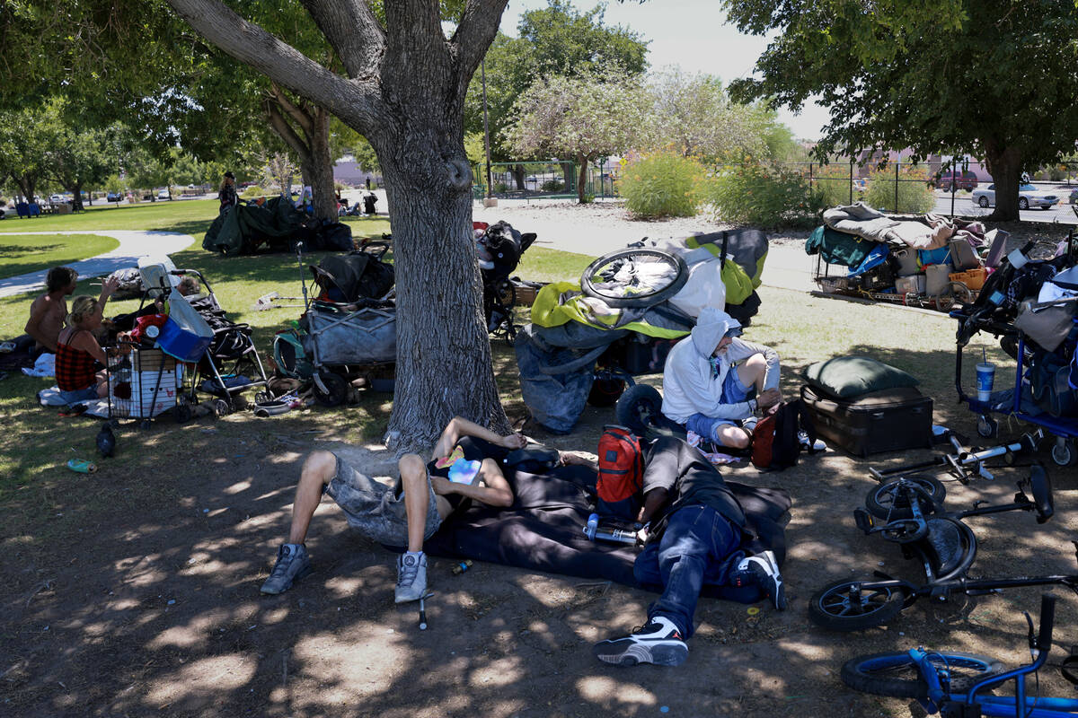 People take shelter from the sun with their belongings at Justice Myron E. Leavitt and Jaycee C ...