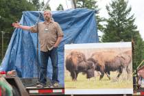 Mike Mease, co-founder of the Buffalo Field Campaign, speaks next to a photograph of a white bu ...