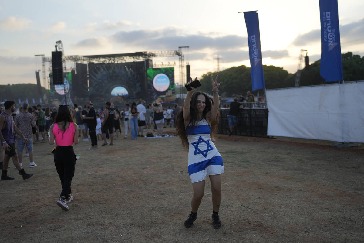 A woman wears a dress in the colors of the Israeli flag at the Nova Healing Concert in Tel Aviv ...