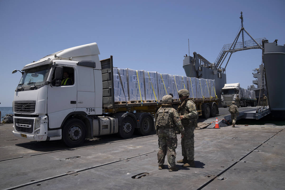 U.S. Army soldiers stand next to trucks arriving loaded with humanitarian aid at the U.S.-built ...