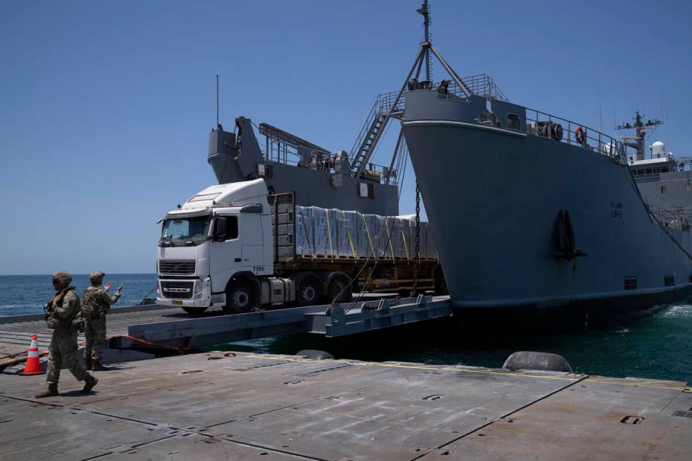 A U.S. Army soldier gestures as trucks loaded with humanitarian aid arrive at the U.S.-built fl ...