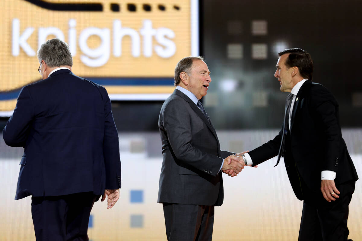 Commissioner Gary Bettman shakes hands with George McPhee, president of hockey operations at th ...