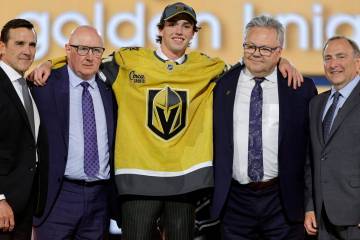 Trevor Connelly, center, poses after being selected by the Vegas Golden Knights during the firs ...