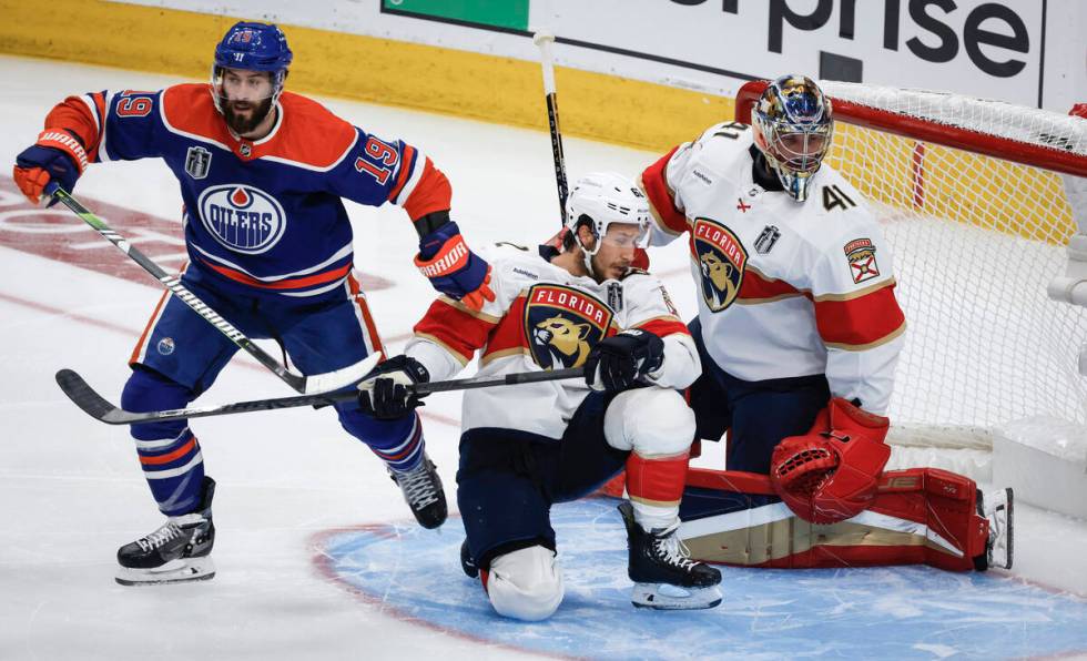 Florida Panthers' Brandon Montour (62) is pushed down by Edmonton Oilers' Adam Henrique (19) in ...