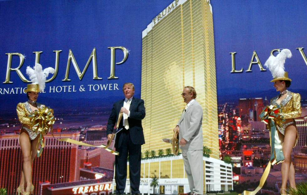 Donald Trump and business partner Phil Ruffin cut a ribbon with the help of two Las Vegas showg ...