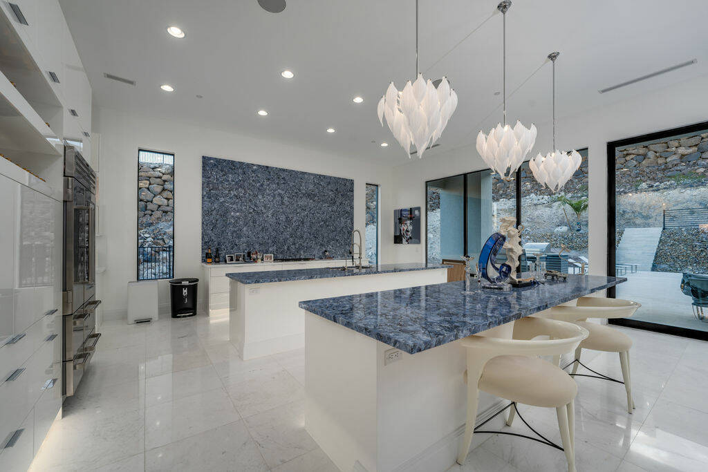 From sleek white epoxy floors and marble walls to blue quartz island in the chef’s kitchen, e ...