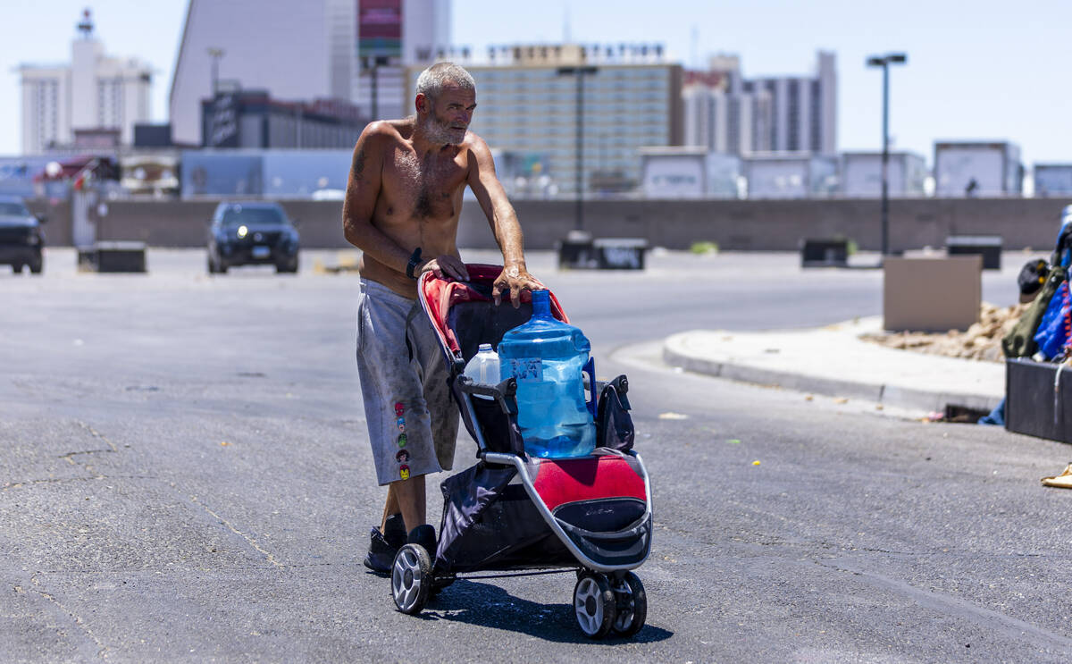 A homeless man wheels a jug of water to his encampment along East Washington Avenue in Las Vega ...