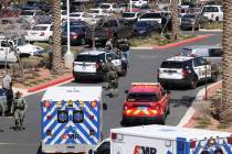 Las Vegas police with a battering ram and crow bar run toward City National Bank Building in Su ...