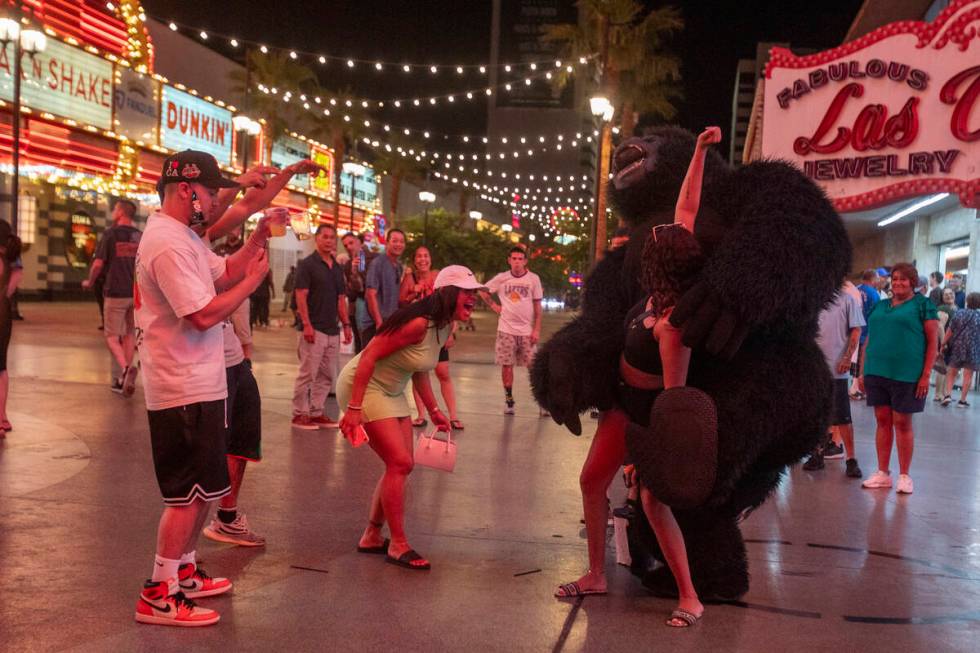 Tourists dance with a gorilla busker at the Fremont Street Experience Monday, July 1, 2024, in ...