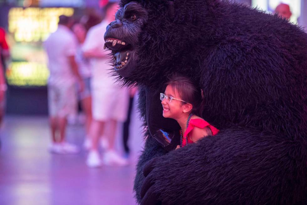 Tourists dance with a gorilla busker at the Fremont Street Experience Monday, July 1, 2024, in ...