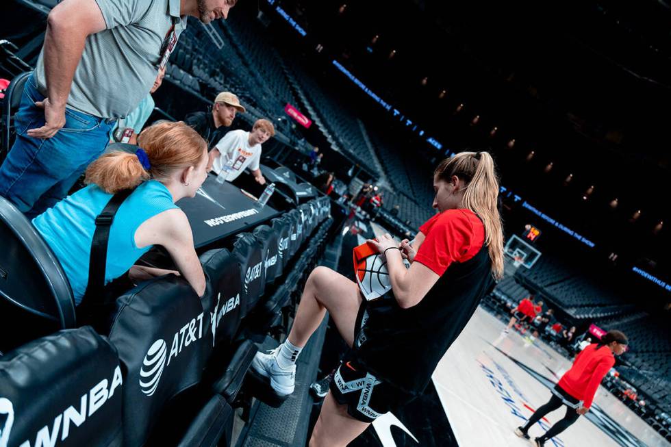 Las Vegas Aces rookie guard Kate Martin signs WNBA basketball for Bailey Lux during practice Mo ...