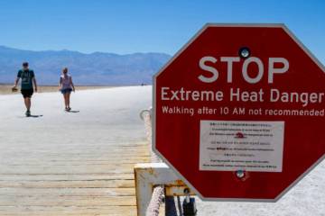 A sign warns people of extreme heat in multiple languages on July 11, 2023, in Death Valley Nat ...