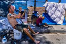 FILE - Homeless man Milton John Scott III pours a jug of water on his head to escape the heat a ...