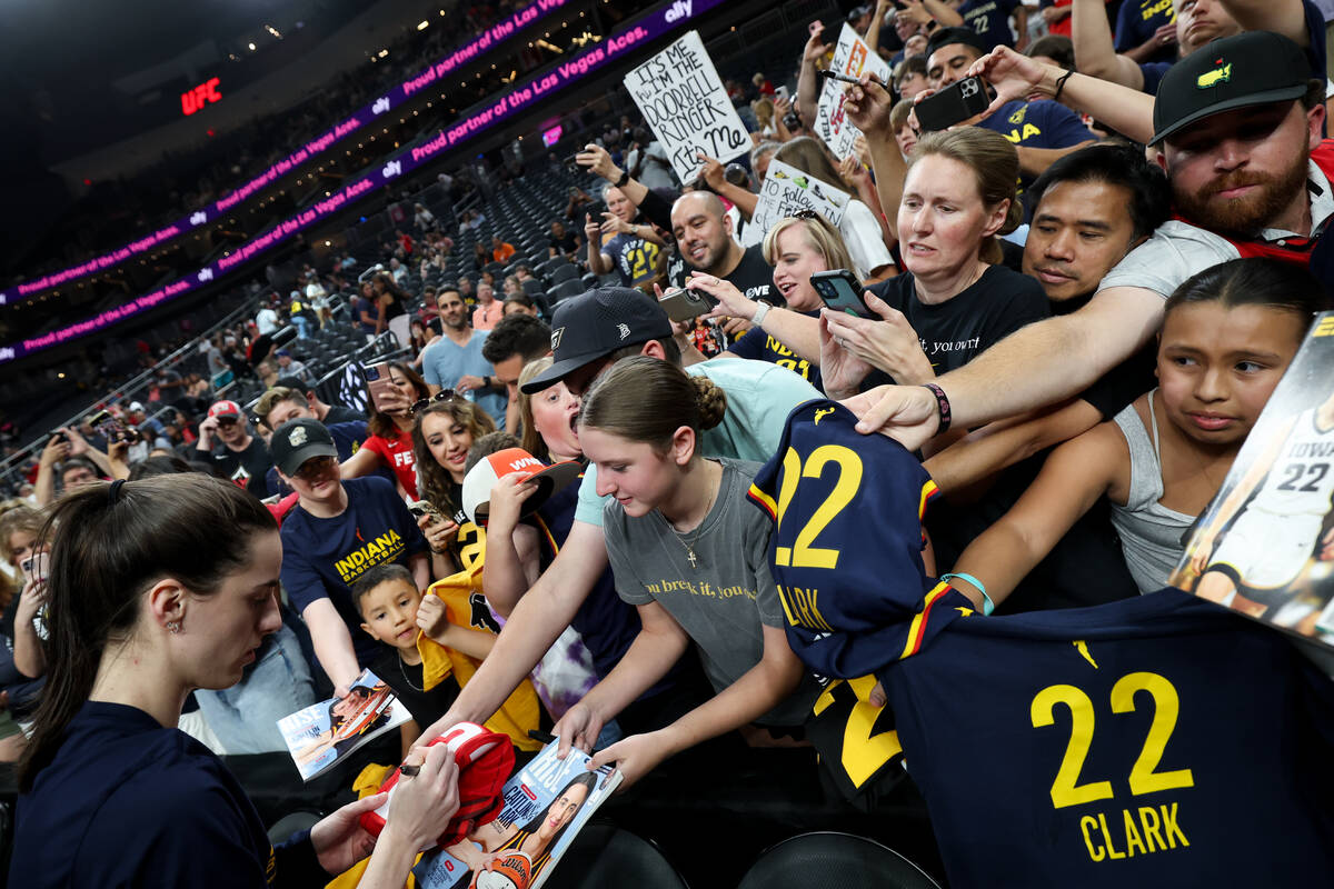 Indiana Fever guard Caitlin Clark (22) signs autographs for fans before a WNBA basketball game ...