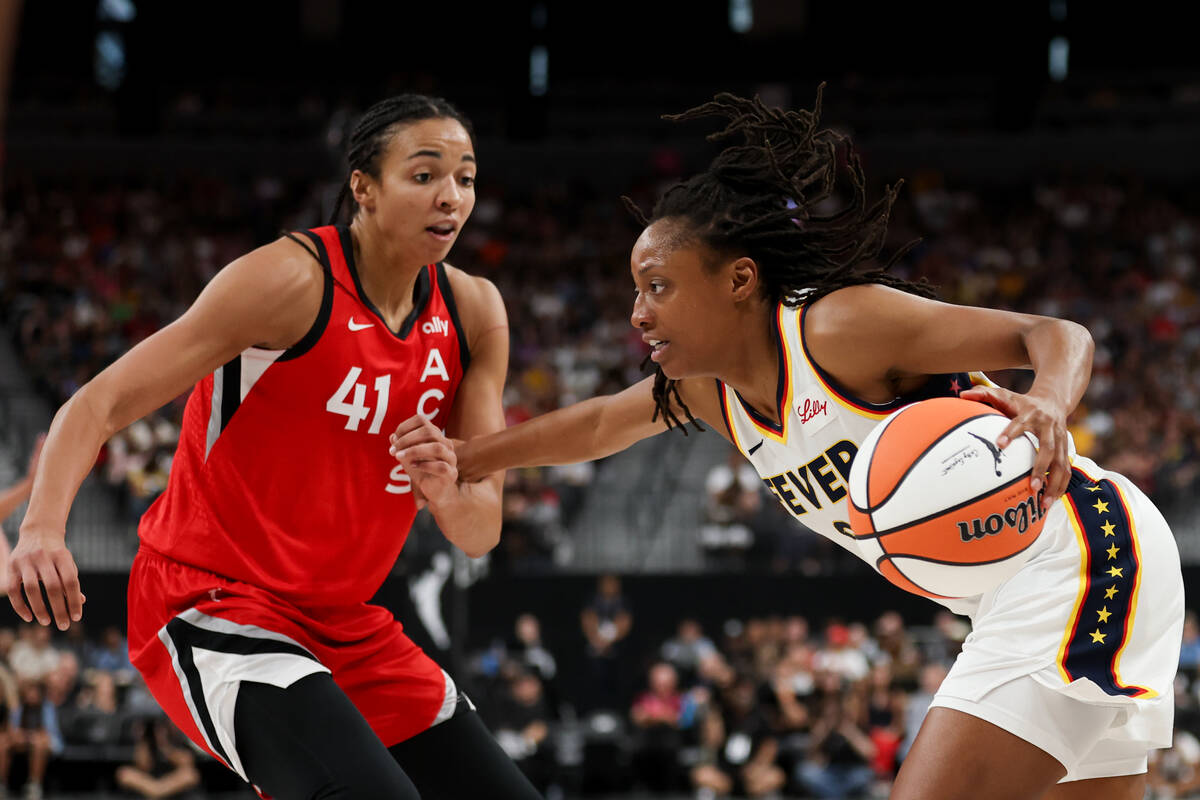 Indiana Fever guard Kelsey Mitchell, right, drives toward the hoop while Las Vegas Aces center ...