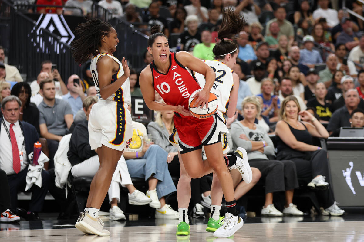 Las Vegas Aces guard Kelsey Plum (10) struggles for a loose ball against Indiana Fever guard Ca ...