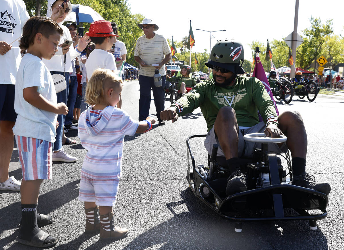 Raivadus Gill of Forgotten Not Gone (FNG) gives a fist bump to two-year-old Graidy Achzet durin ...