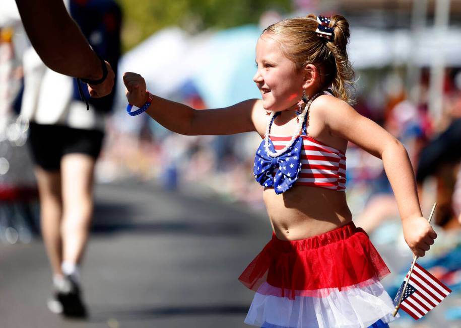 Scarlett Legrow exchanges fist bumps with a parade participant during the annual Summerlin Coun ...