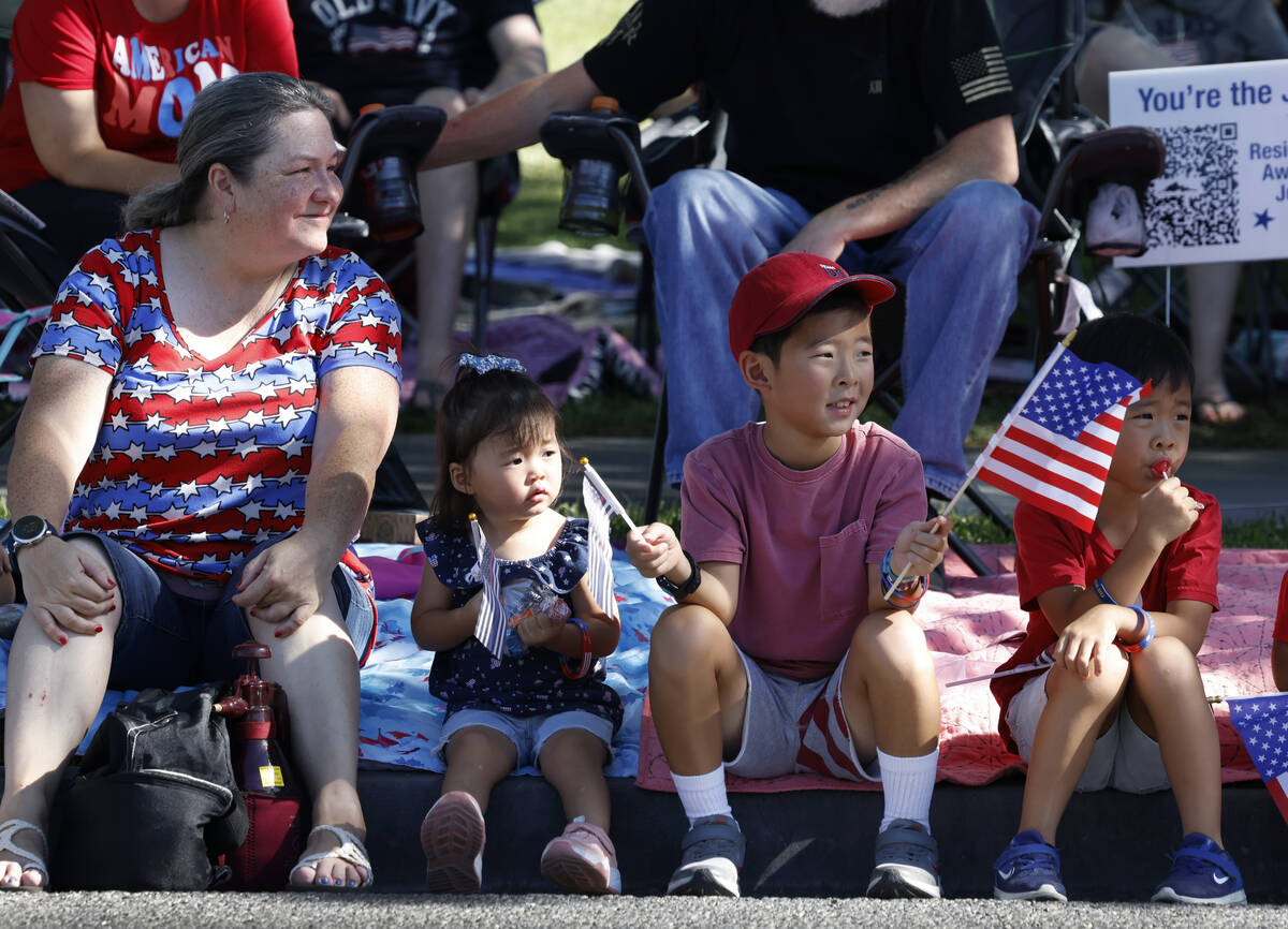 Delane Elliott, left, Elisabeth Bartlett, 2, and her brother Alex, 8, second right, watch the a ...