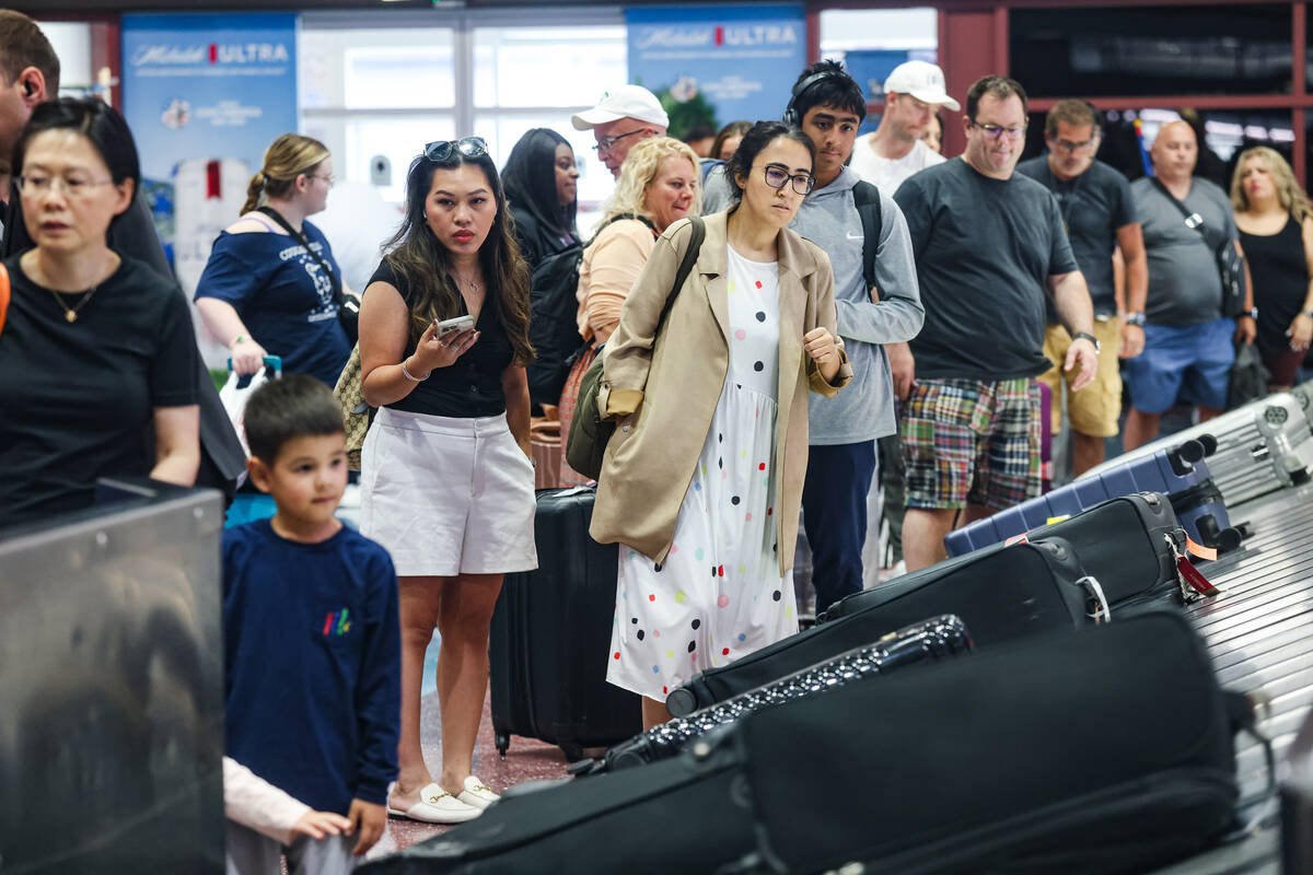 Guests wait for their luggage in the baggage claim area of Harry Reid International Airport in ...
