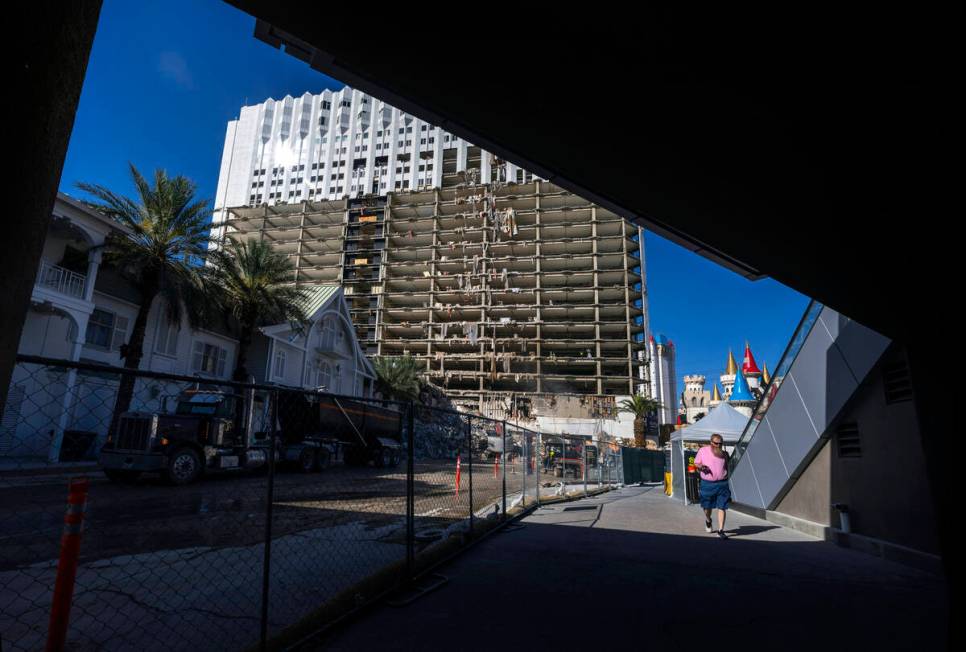 A pedestrian walks beneath a bridge as demolition continues on the Tropicana in preparation for ...