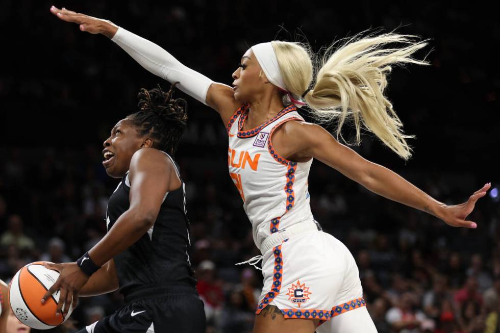 Las Vegas Aces guard Chelsea Gray, left, drives toward the hoop while Connecticut Sun guard DiJ ...