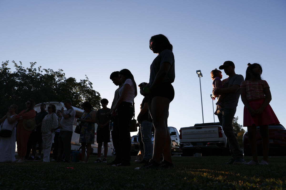 Loved ones of Alondra Rivera bow their heads in prayer during a vigil at Winterwood Park on Wed ...