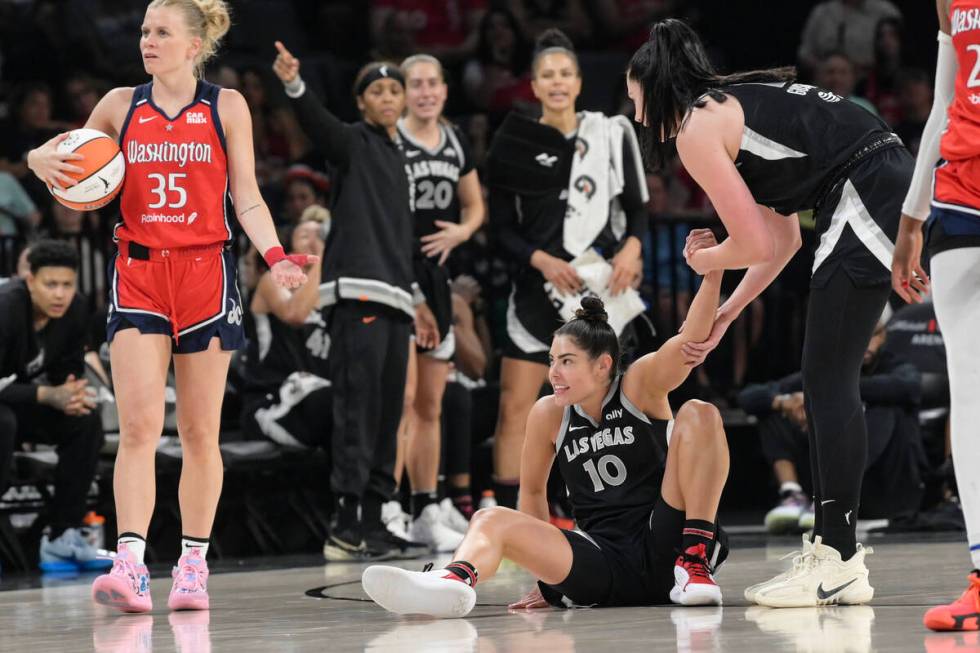 Las Vegas Aces guard Kelsey Plum (10) is helped up after being fouled by Washington Mystics gua ...