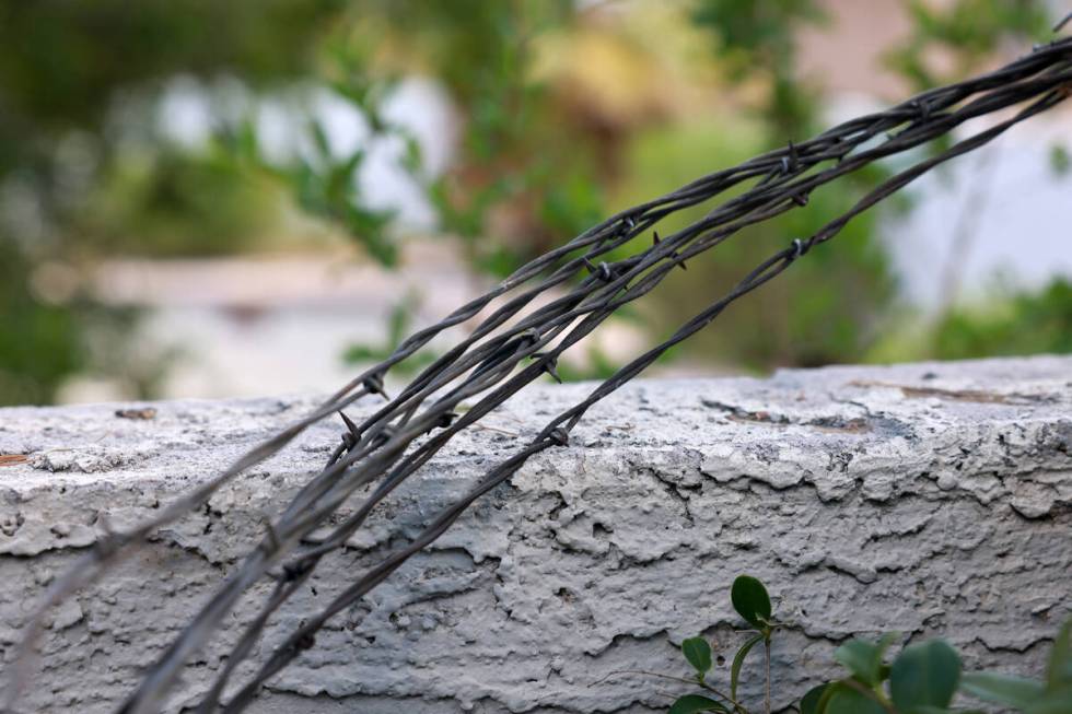 Barbed wire is seen on the backyard wall at the home of Jami Whitehead in The Lakes Monday, Jun ...