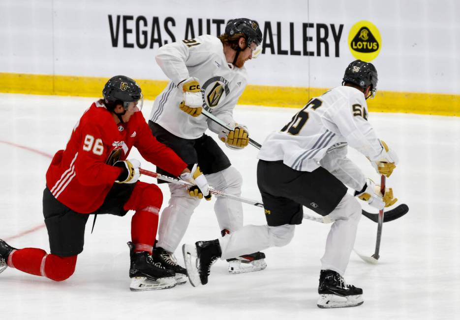 Golden Knights defensemen Samuel Mayer (96) forward Jett Jones (91) and forward Tyler Kopff (56 ...