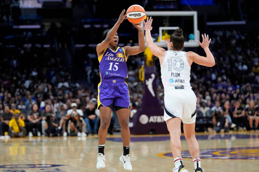 Los Angeles Sparks guard Aari McDonald, left, shoots against Las Vegas Aces guard Kelsey Plum d ...