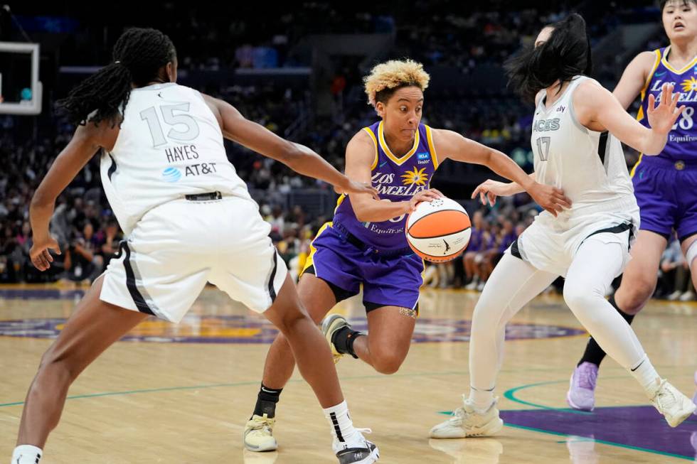 Los Angeles Sparks guard Layshia Clarendon, center, drives against Las Vegas Aces guard Tiffany ...