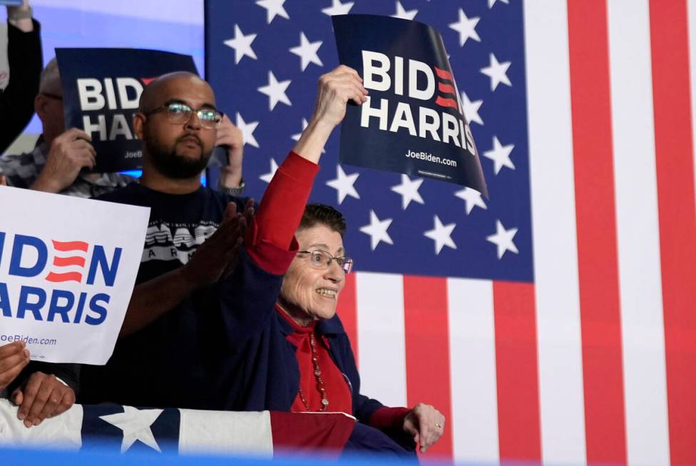 Supporters of President Joe Biden hold signs at a campaign rally at Sherman Middle School in Ma ...