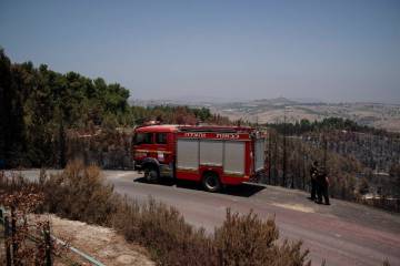 Firefighters check a burned area at Biriya Forest, from previous shelling attacks from Lebanon, ...