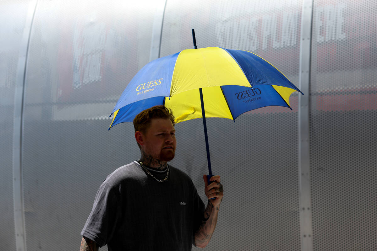 A fan shields himself from the sun while waiting for autographs from the USA Basketball Men&#x2 ...