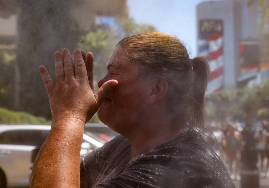 Jenni Athon, of Cincinnati, cools off in front of misters outside Paris Las Vegas hotel-casino, ...