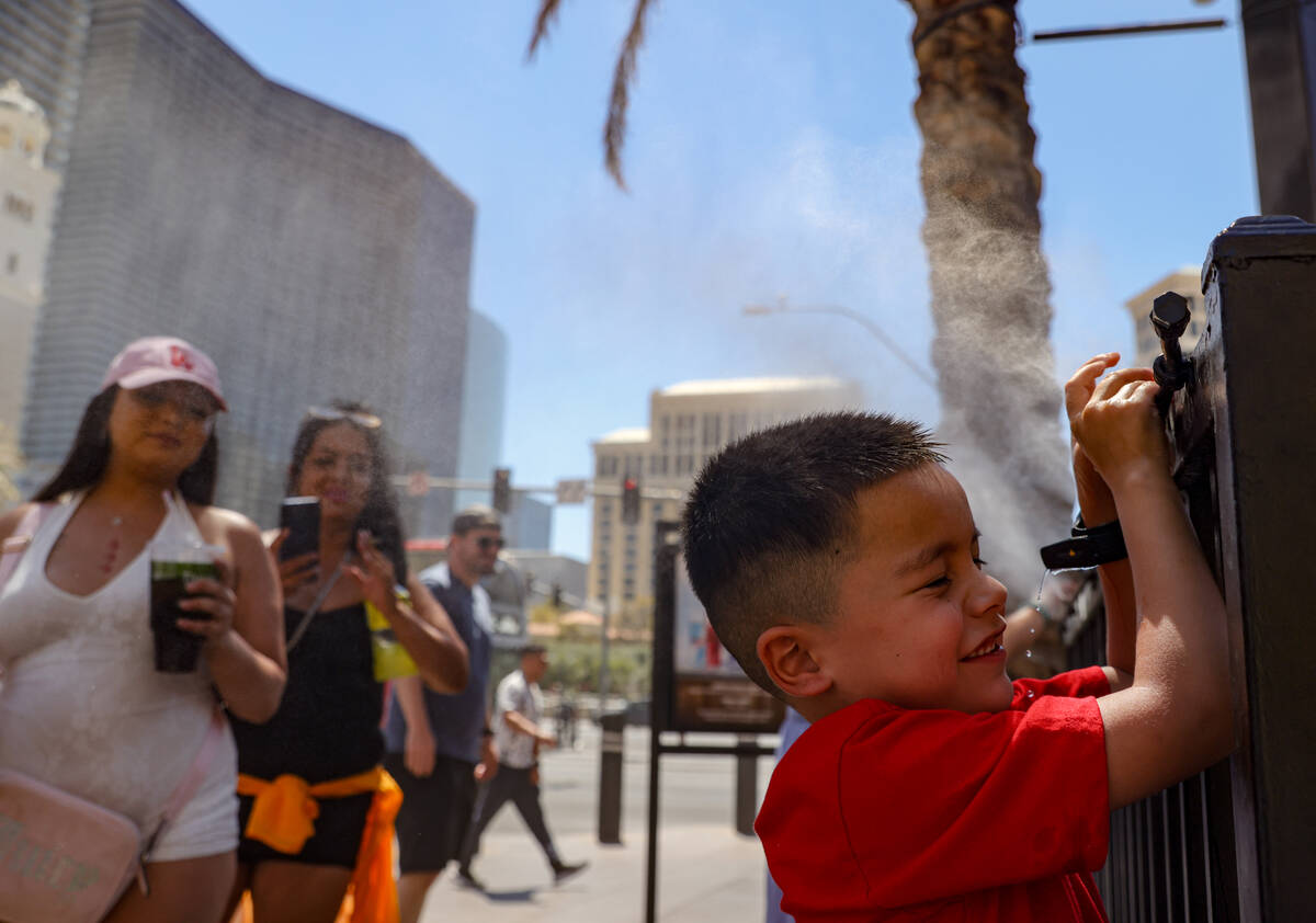 Josiah Ornelas, 6, cools down in front of misters outside Paris Las Vegas hotel-casino, Sunday, ...