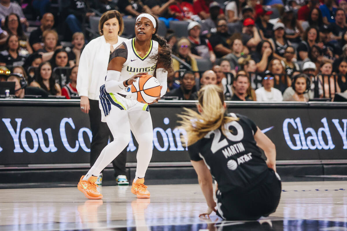 Dallas Wings guard Arike Ogunbowale (24) attempts a basket as Aces guard Kate Martin (20) falls ...