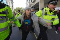 Environmental activist Greta Thunberg is taken away by police officers during the Oily Money Ou ...