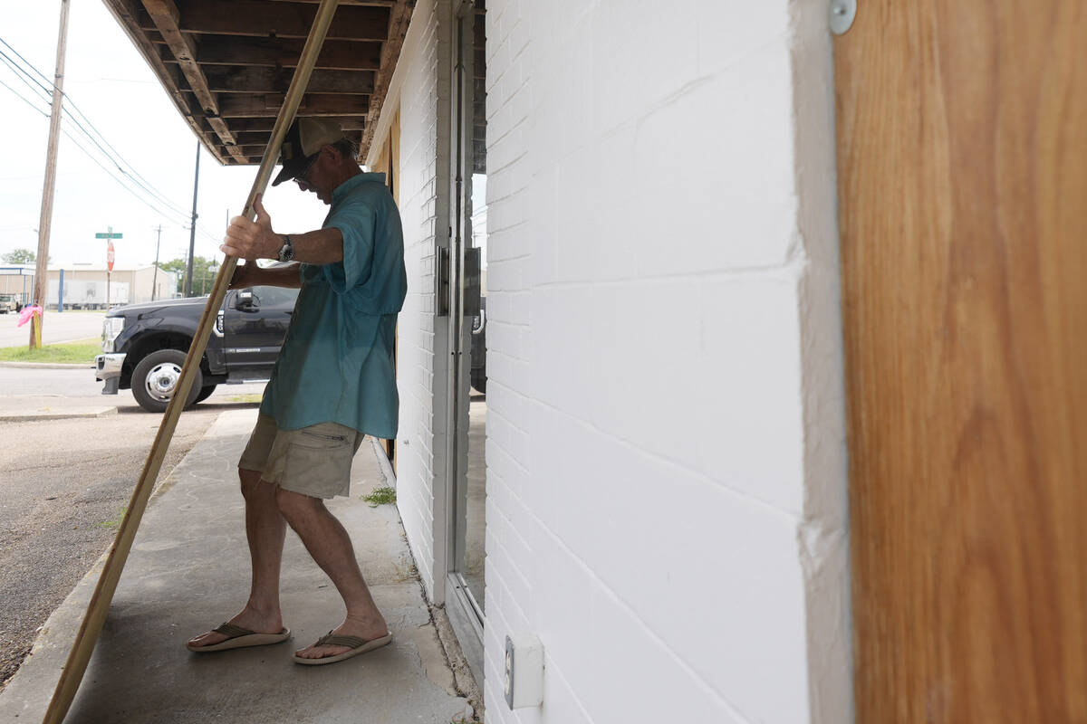 Jimmy May boards windows as he prepares for Hurricane Beryl's arrival, Sunday, July 7, 2024, in ...