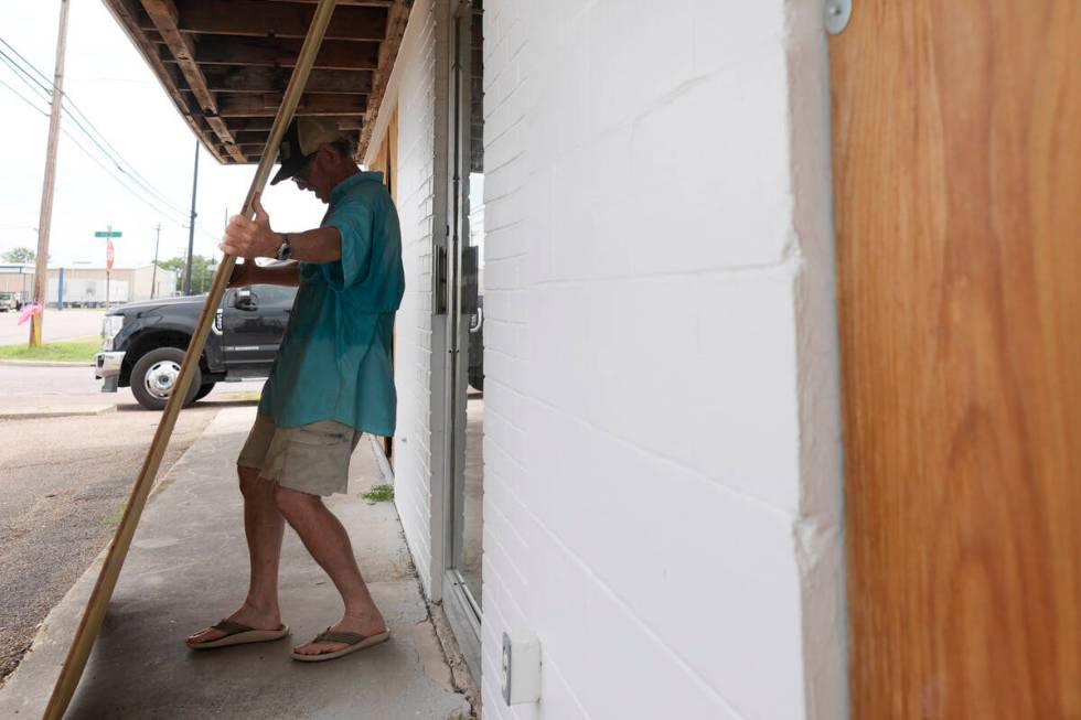 Jimmy May boards windows as he prepares for Hurricane Beryl's arrival, Sunday, July 7, 2024, in ...