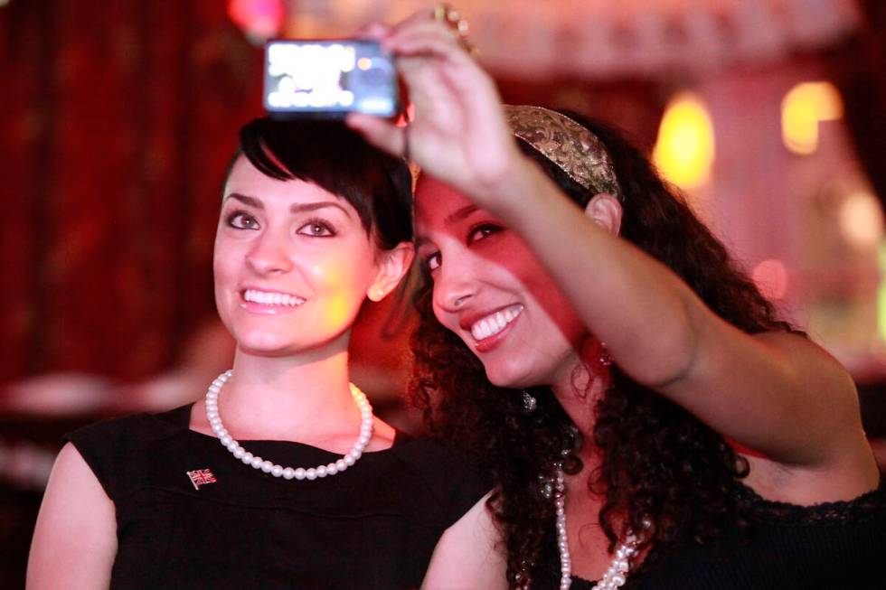 Rebecca Stevens, left, and Aneya Fernando take a self portrait while watching coverage of the r ...